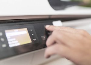 finger pushing scan on a copier for onsite scanning