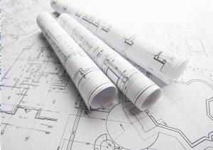 technical drawings rolled up and displayed on a table